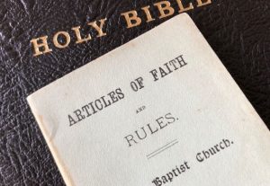 A black leather Bible with a booklet on top
