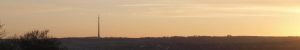 A landscape showing Emley Moor mast in the sunset